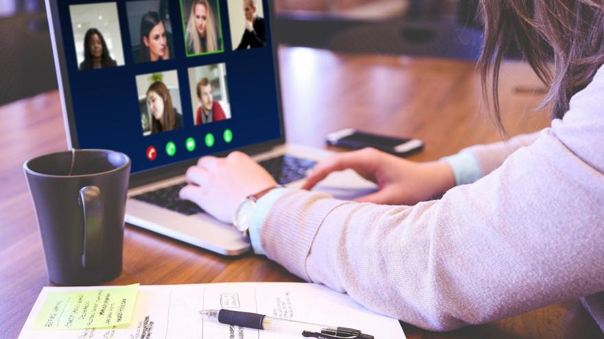 Arme und Hände einer Frau am Laptop mit verschiedenen Gesichtern auf dem Display