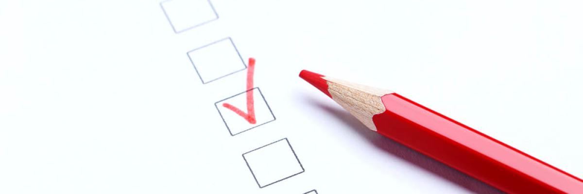 Checkliste mit Haken und rotem Stift